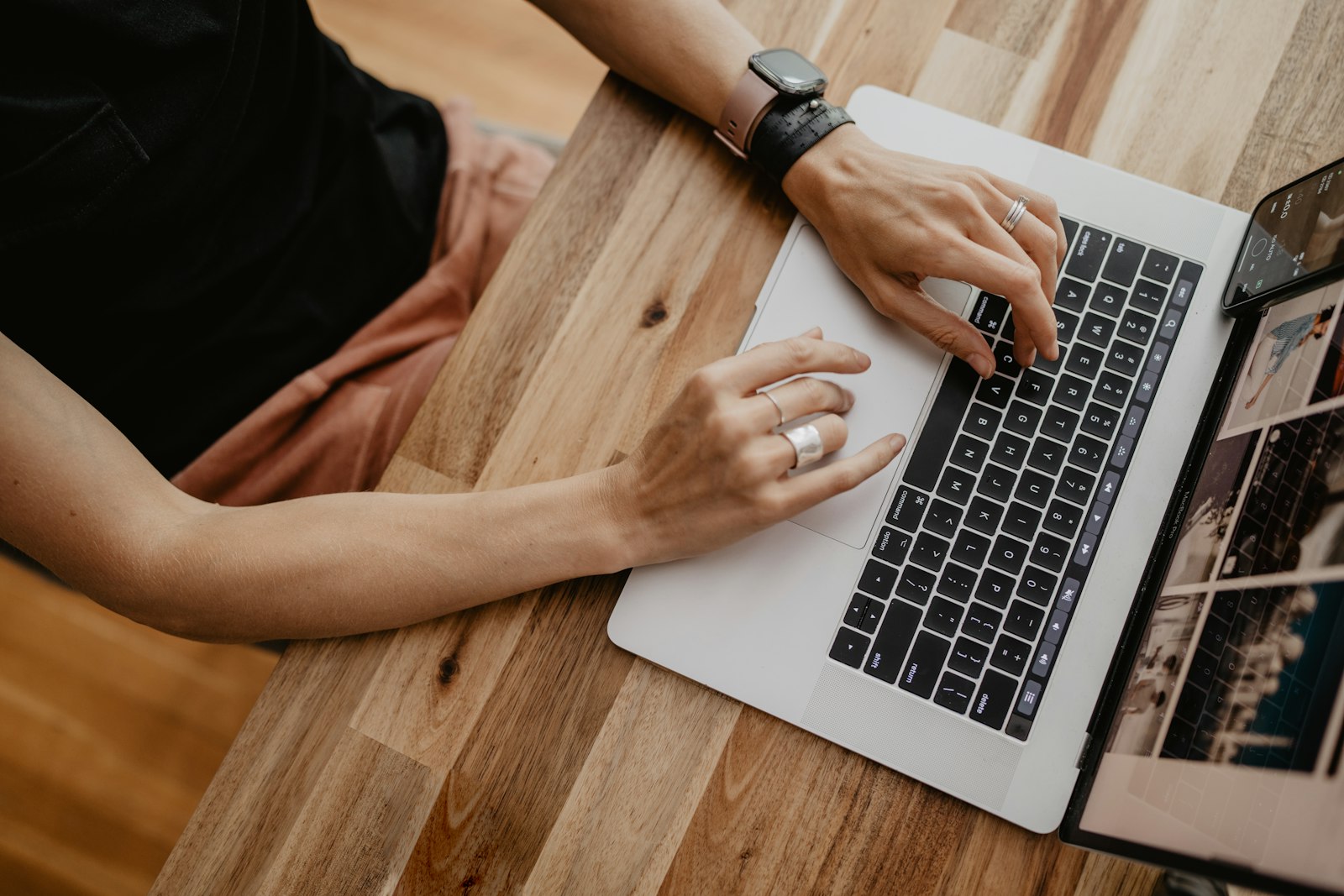 Hands typing on a laptop at a home desk
